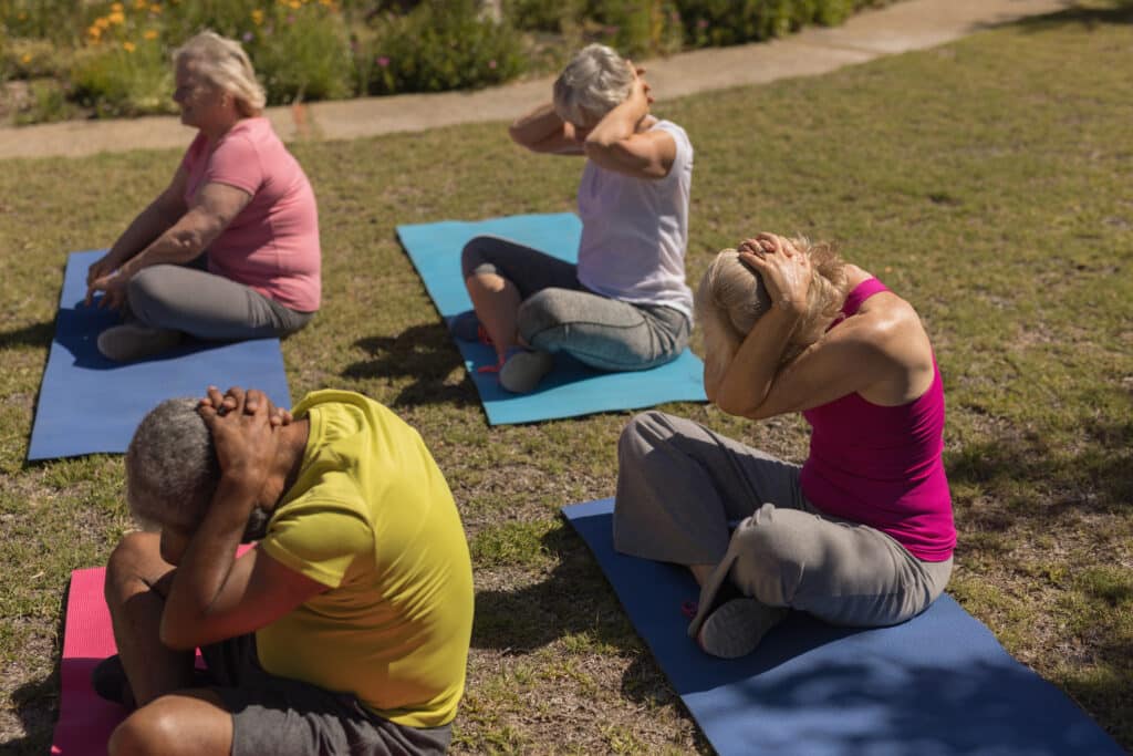 Groupe de Senior pratiquant le Yoga dans un parc public