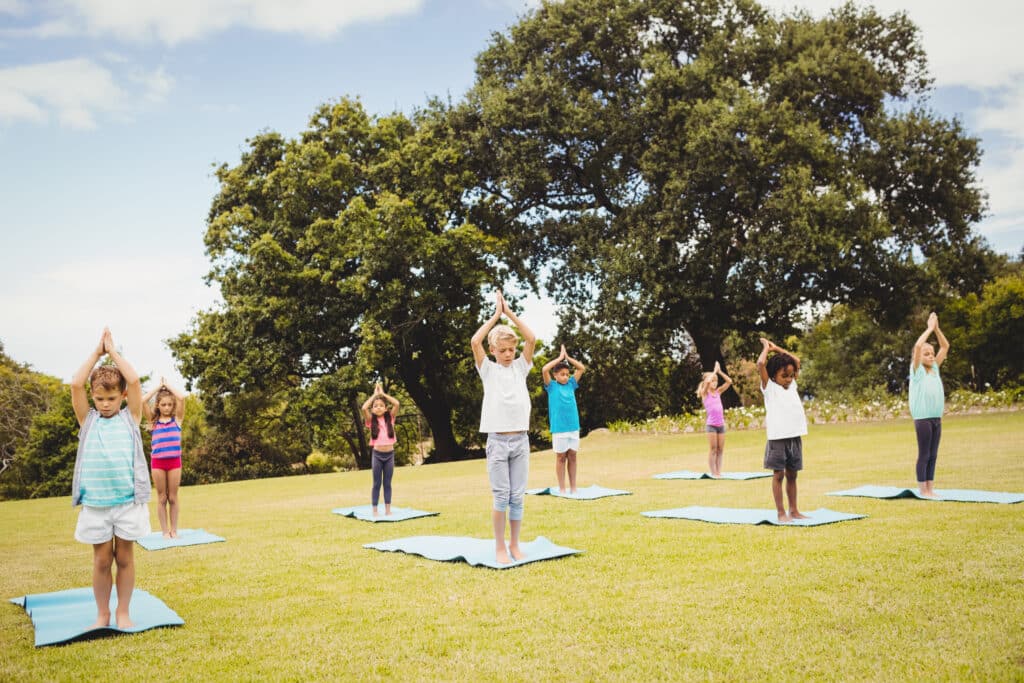 Enfant pratiquant le Yoga dans un jardin